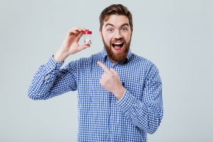 man happily shows supplement bottle